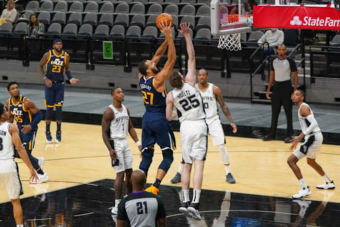 Rudy Gobert (27) scores over Jakob Poeltl (25) 